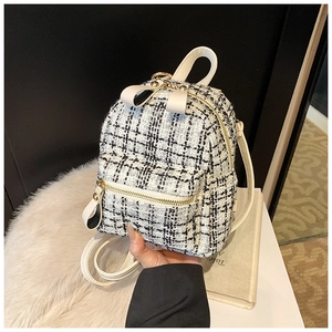 Close-up of black and white tweed mini backpack with white faux leather trim details