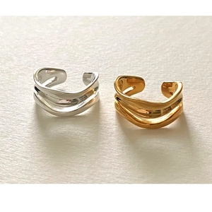 Close-up of gold and silver minimalist wavy rings with irregular curved lines