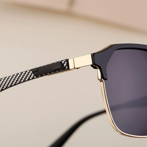 Detailed macro shot of sunglasses with carbon fiber texture and gold metal hinges