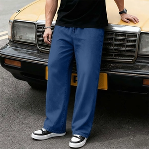Jean en denim bleu foncé pour homme à jambe large montré dans un décor de rue avec voiture