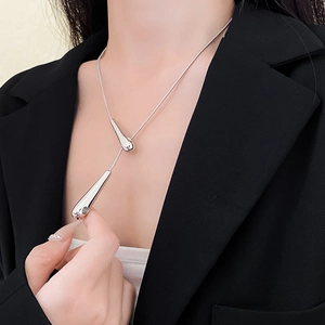 Détail du collier chaîne serpent argentée avec pendentifs gouttes asymétriques
