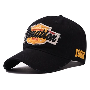 Detail of distressed brim and yellow 1968 embroidery on a black cotton baseball cap