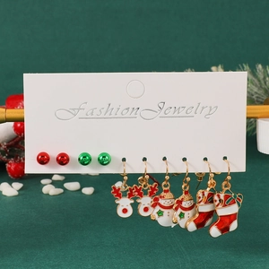 Close-up of five pairs of Christmas earrings with reindeer, snowman and tree charms