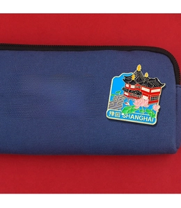 Detail of blue canvas bag with Fudan University print and Shanghai Yu Garden enamel pin