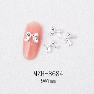 Macro view of MZH-8684 silver alloy bow nail charm sized 9x7mm on pink manicure