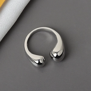 Minimalist silver fluid droplet open ring with a polished metallic mirror finish