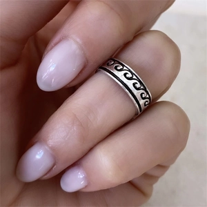 Macro shot of S925 sterling silver vintage ring with wave patterns on hand