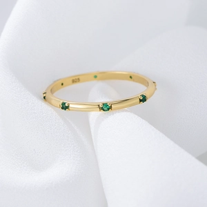 Elegant 925 silver gold-plated ring with round green zircon stones on white fabric
