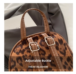 Detail shot of leopard print backpack showing adjustable faux leather straps and metal buckle