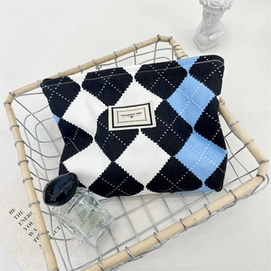 Detailed close-up of a blue and black checkered cosmetic bag in a rustic metal basket