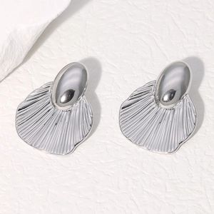 Minimalist silver stainless steel shell earrings with ribbed texture on rock background