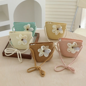 Detail of colorful woven straw mini crossbody bags with large fabric flowers and sequins