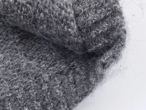 Close-up of high-quality dark grey knit fabric with soft mohair texture detail