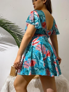 Detail of tropical leaf print and backless design on a light blue tankini swim dress