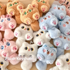 Close-up of cute plush animal keychains with big eyes and embroidered paw pads