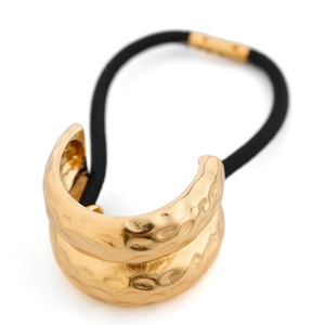 Detail of golden hammered metal ponytail cuff with high elastic black hair tie
