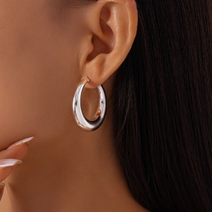 Polished silver circular hoop earring shown on model for a minimalist jewelry look
