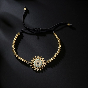 Detail of adjustable woven bracelet with sunflower charm and turquoise zircon inlays