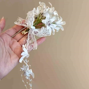 Detail of floral lace hair clip with pearls and elegant tassel fringe decoration
