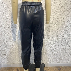 Dettaglio dei pantaloni in ecopelle nera con vita elastica alta e polsini alla caviglia