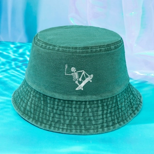 Green washed cotton bucket hat featuring a vintage skateboard skull print design