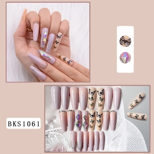 Detail of long coffin press-on nails with purple butterfly art and 3D rhinestones