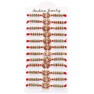 Set of 12 red woven bracelets with golden butterfly charms and crystals on a white card