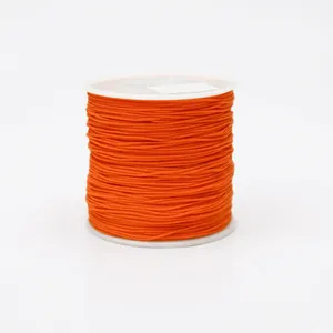 Detailed view of 0.8mm orange nylon cord on a spool for DIY jewelry and knotting