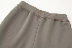 Detail of dark grey sweatpants featuring elastic waistband and drawstring gathered waist