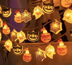 Detail of LED Halloween string lights with pumpkin, ghost, and cat shapes glowing brightly
