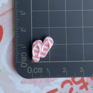 Mini tongs rayées roses sur tapis de coupe montrant les dimensions de 1,5 cm x 0,8 cm