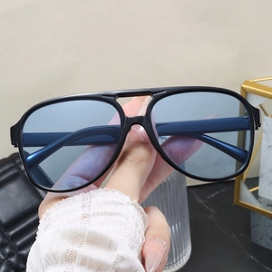 Detailed close-up of retro aviator sunglasses featuring black frames and light blue lenses