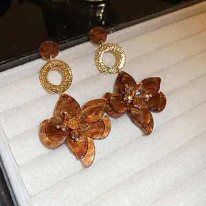 Retro amber flower drop earrings with golden rings on white velvet jewelry display box