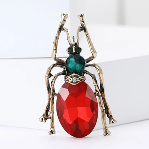 Detail of beetle brooch featuring a large red faceted gem and antique bronze finish