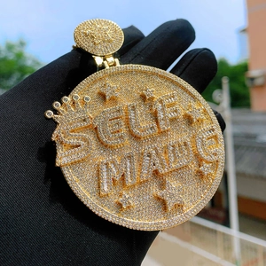 Close-up of gold-plated hip hop shield pendant with SELF MADE lettering and zircons