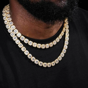 Close-up of double layered gold Cuban link necklaces with sparkling round clear zircons