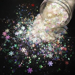 Macro view of cloud-like pearlescent iridescent sequins in star and snowflake shapes