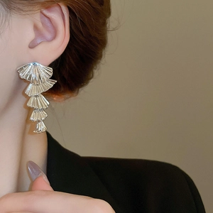 Silver fringe tassel earrings with layered fan design shown on a model side view