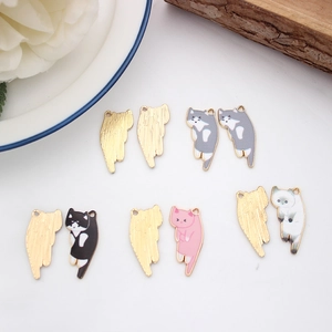 Detail of colorful cat charms in pink, grey and white with polished gold alloy edges