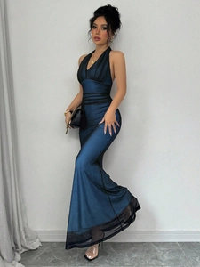 Detail of teal halter neck dress featuring a sleek mermaid cut and sheer mesh hemline