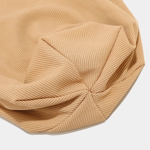 Macro shot of khaki rib-knit beanie crown showing professional stitching and fabric texture