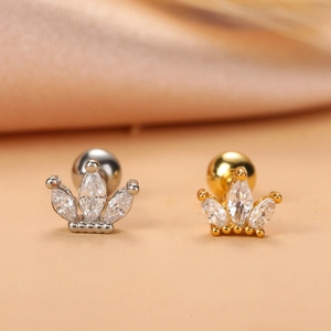 Detail of crown shaped stud earrings in gold and silver finish with zircon stones