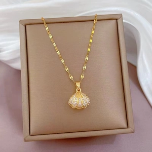 Elegant gold-plated seashell pendant necklace with sparkling white zircons on a leather box