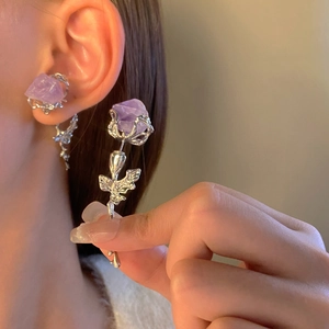 Detail von silbernem Rosenohrring mit lila Stein und passendem Stecker am Model