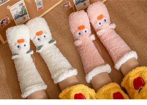Detailed close-up of fuzzy coral fleece floor socks with cute cartoon animal faces