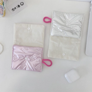 Quilted bow-patterned pouches in pink and silver with pink lanyards on white table