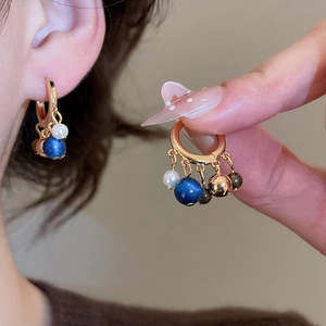 Detail of 18k gold plated hoop earring with tiger eye, pearls and tassel pendants