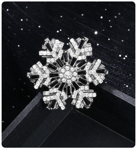 Macro detail of snowflake brooch with black baguette stones and silver rhinestones