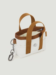 Dettaglio di un mini ciondolo per borsa in tela con chiusura a moschettone argento