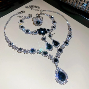 Sparkling silver jewelry set with dark blue teardrop stones and floral diamond accents